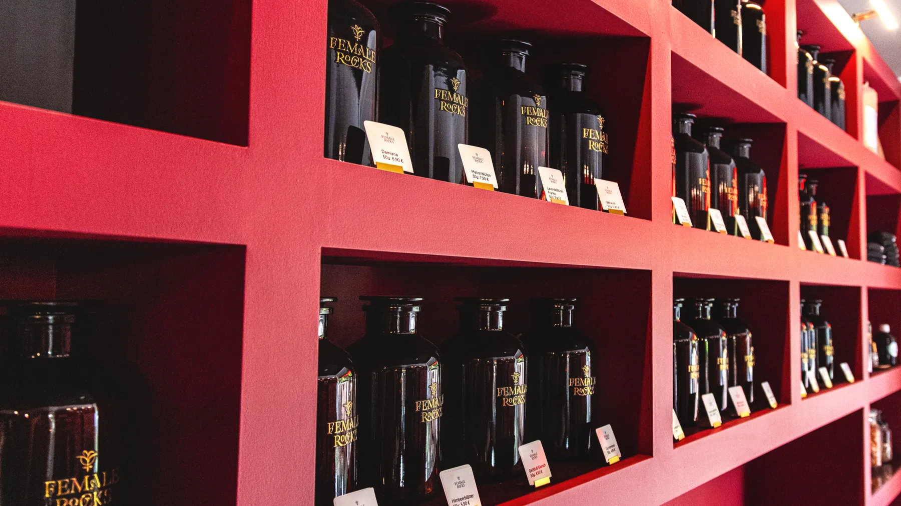Apothekerflaschen mit losen Kräutern im Regal bei Female Rocks